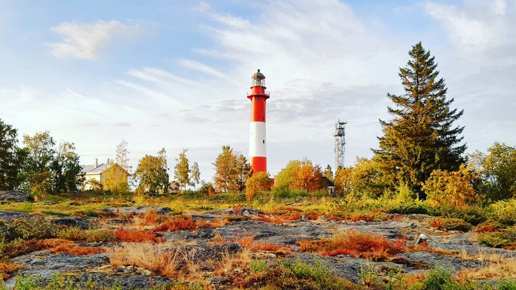 Tankarin majakkasaaren ruskassa loistavat punaisen, oranssin ja kullan sävyt jotka korostuvat karun kalliorannan ja meren syvänsinistä vasten.